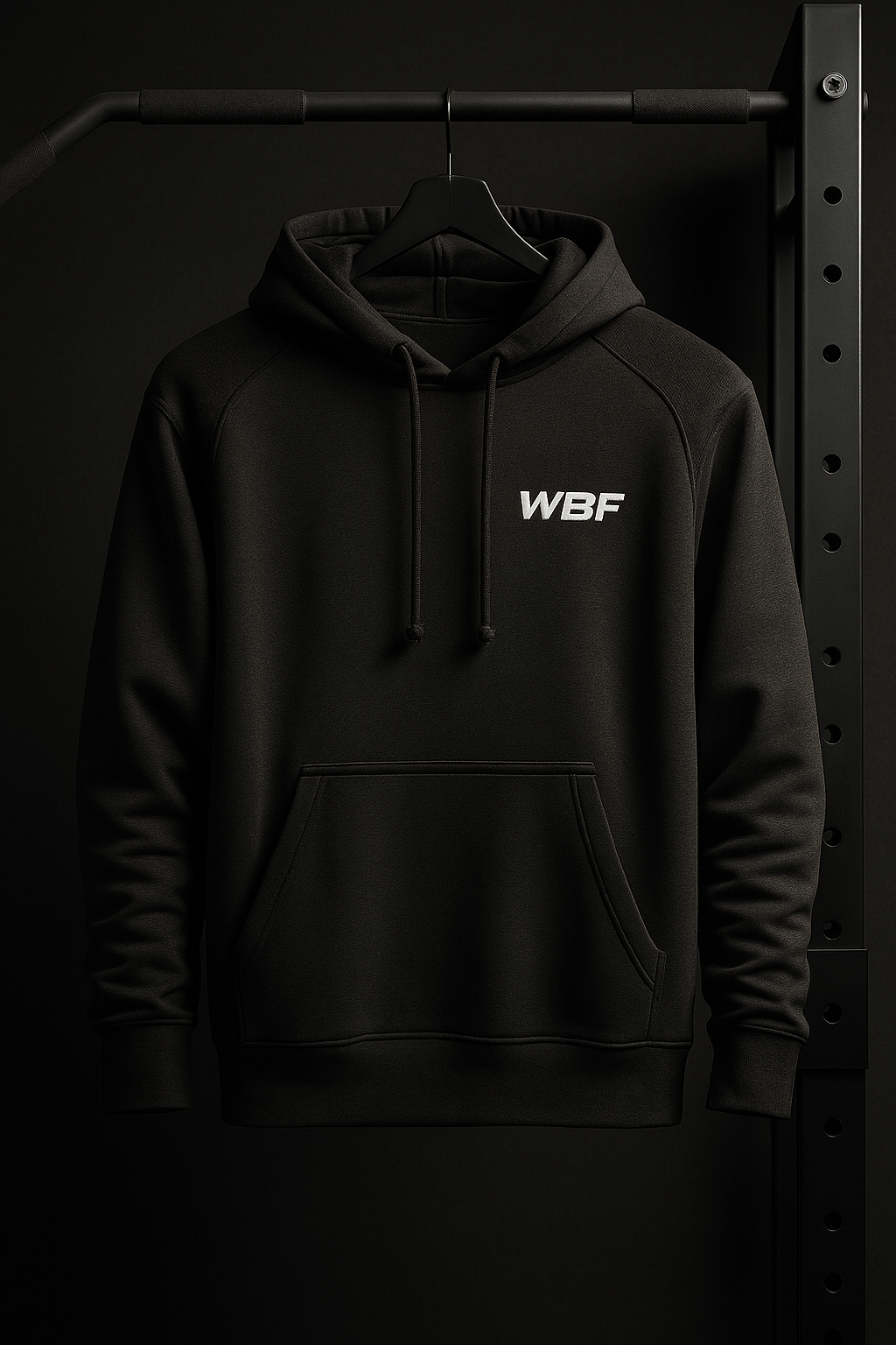 Sudadera negra de Wear Be Fit colgada en ambiente de gimnasio